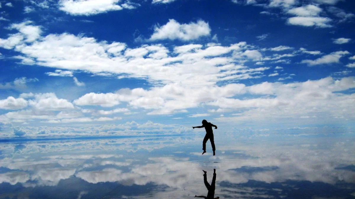 Um homem parece estar voando, mas está apenas pulando o Salar de Uyuni, um deserto de sal na Bolívia.